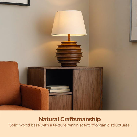 Wooden lamp on a side table with an armchair in a room setting, emphasizing natural craftsmanship.