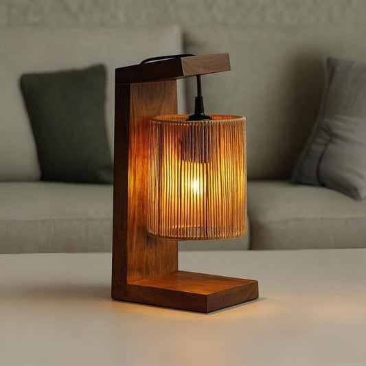 Wooden table lamp with a warm glow on a surface, blurred sofa in the background