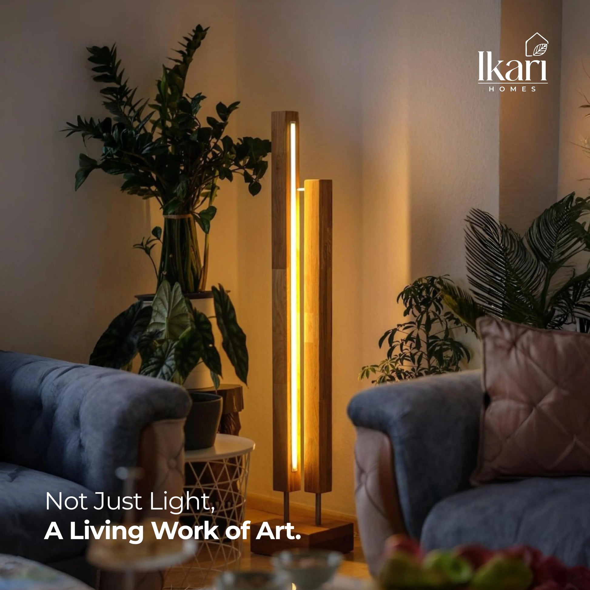 Modern living room with a floor lamp and decorative plants, featuring the Ikari Homes brand.