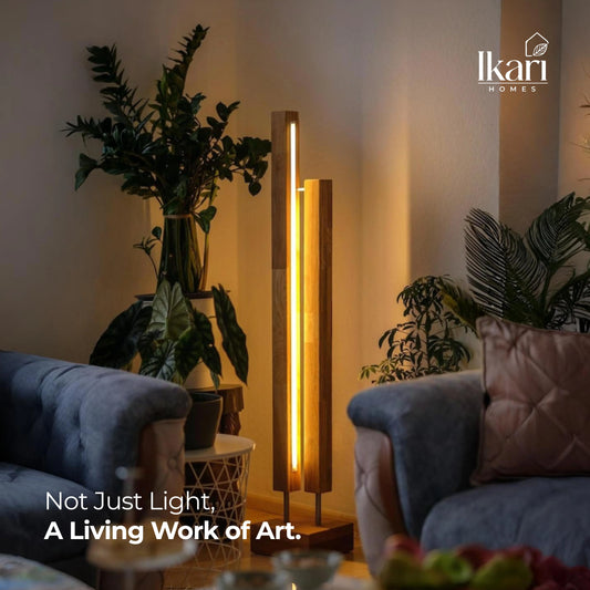 Modern living room with a floor lamp and decorative plants, featuring the Ikari Homes brand.