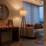 Living room with a couch, lamp, and decorative items. Floor lamp by Ikari Homes